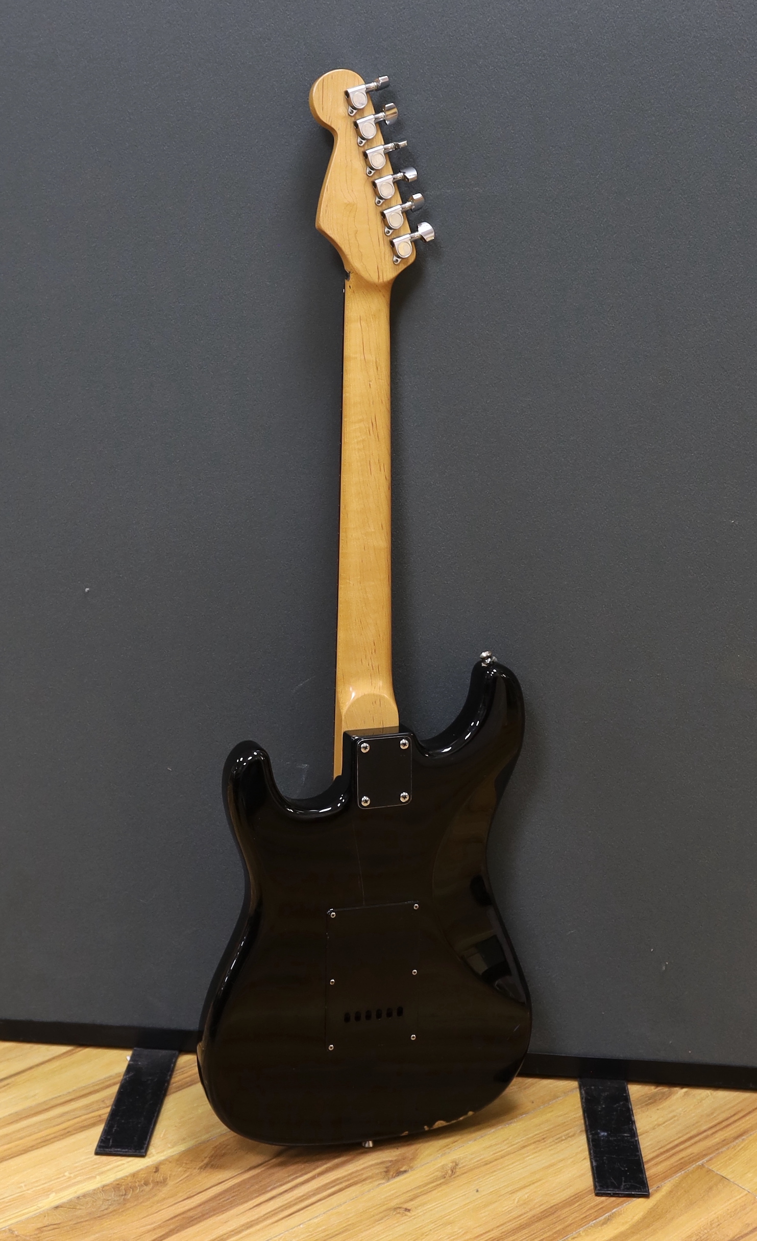 A cased Squier Strat by Fender electric guitar with rosewood neck and balance lacquer body, together with a Harris Tweed flight case